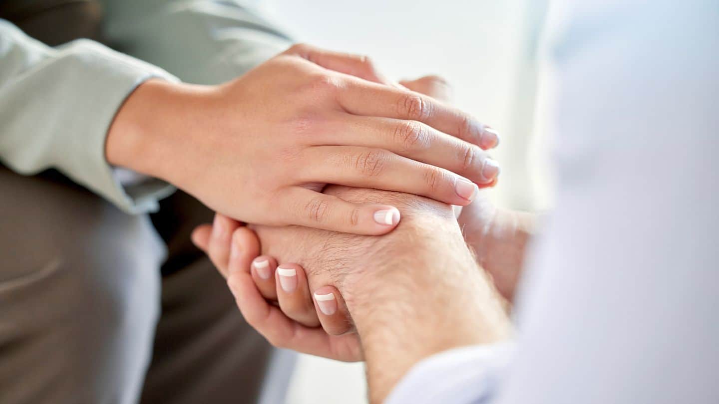 A woman holding someone's hands to help with myths about PTSD.